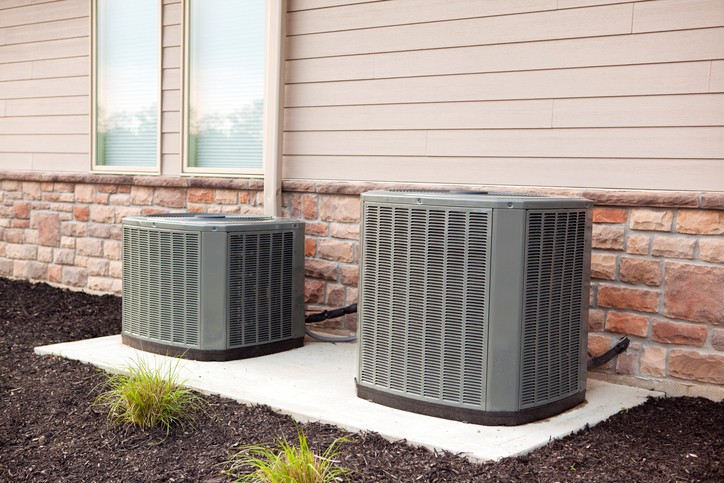 Photo of AC system outside of a home with tan siding